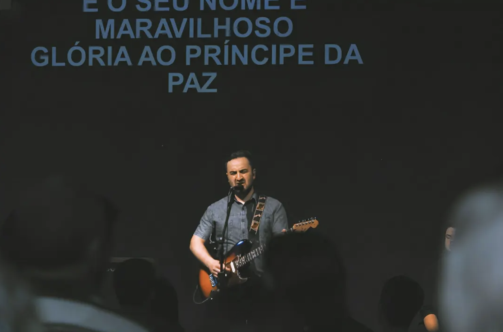 Músico tocando guitarra durante o louvor congregacional