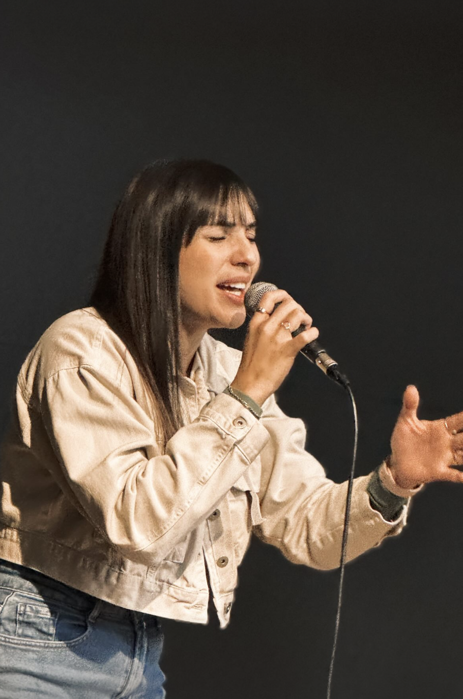 Mulher cantando ao microfone durante o louvor